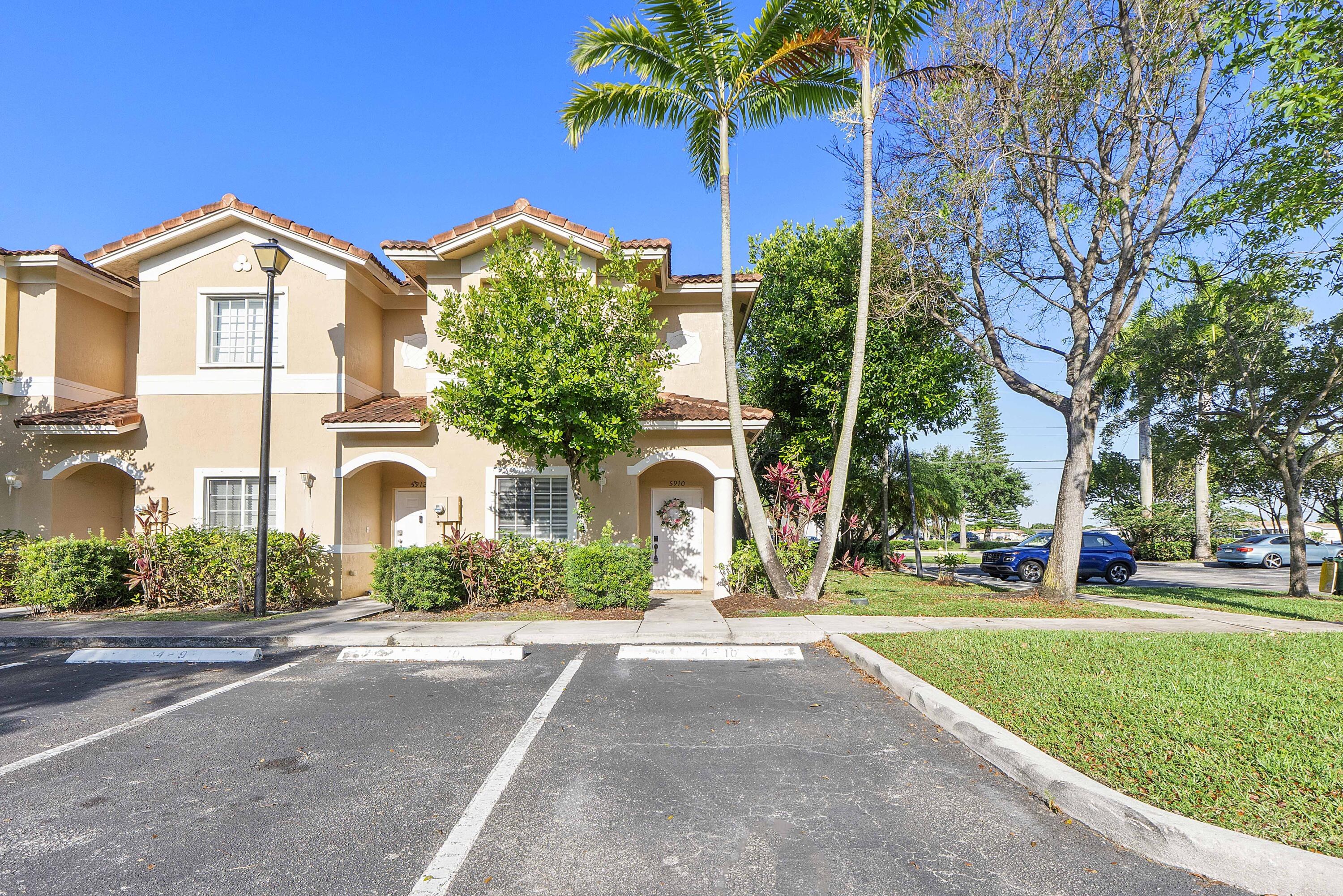 5910 Riverside Avenue Tamarac, FL 33321 - Photo 1 of 47 a front view of a house with a yard and garage