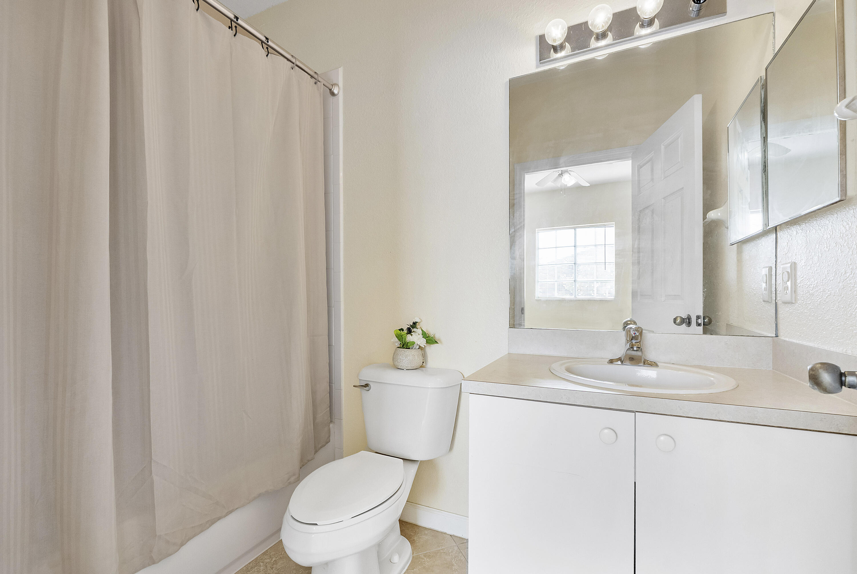 5910 Riverside Avenue Tamarac, FL 33321 - Photo 24 of 47 a bathroom with a sink a toilet and a mirror