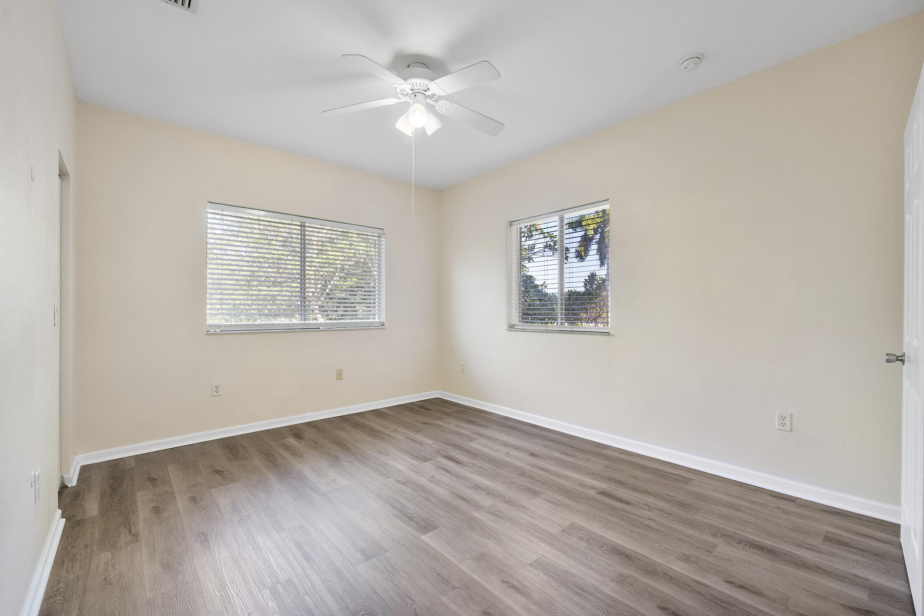 5910 Riverside Avenue Tamarac, FL 33321 - Photo 27 of 47 a view of an empty room with wooden floor and a ceiling fan