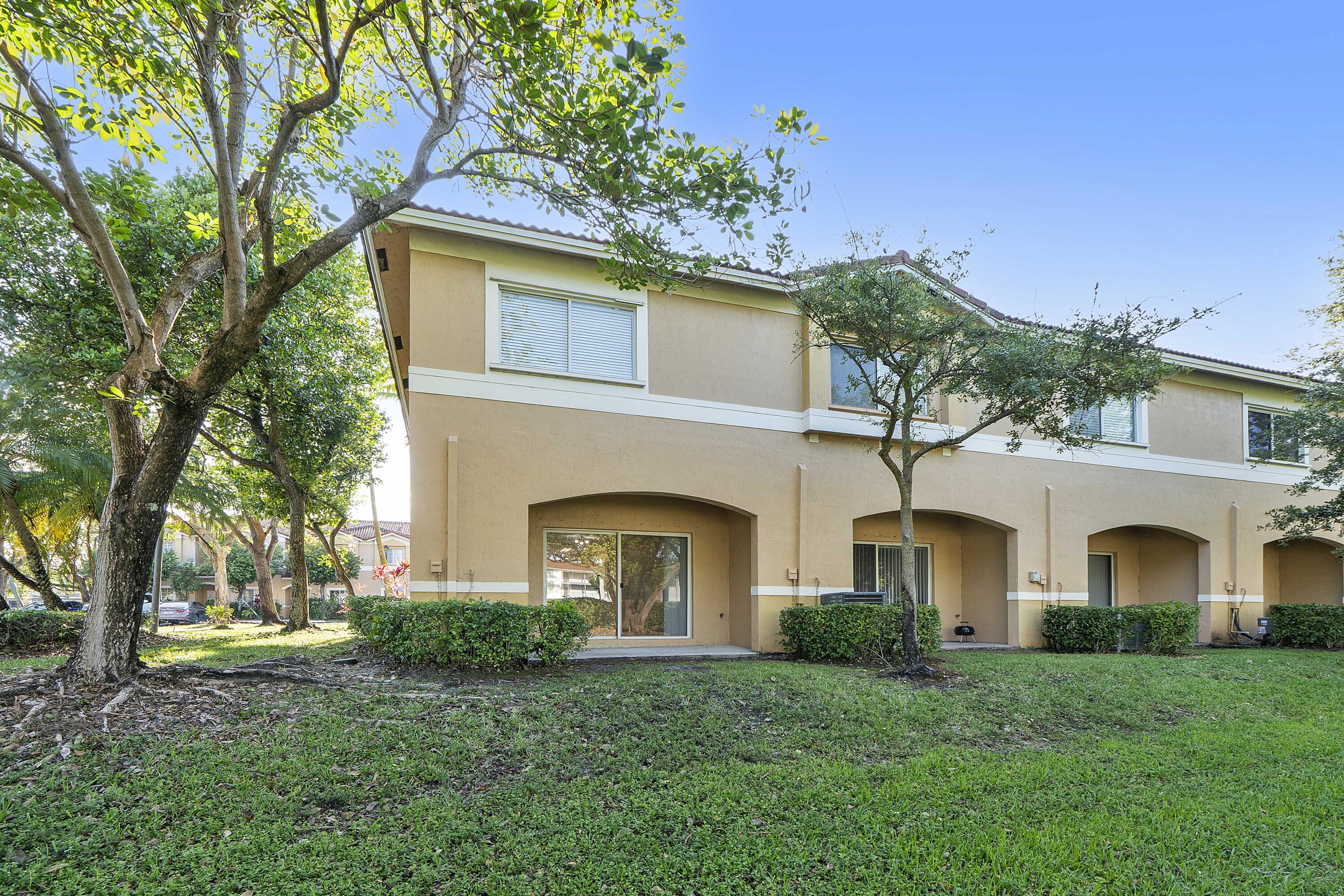 5910 Riverside Avenue Tamarac, FL 33321 - Photo 32 of 47 a front view of a house with a garden