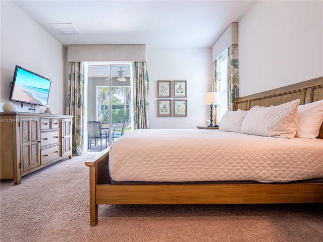 a bedroom with a bed a dresser next to a window