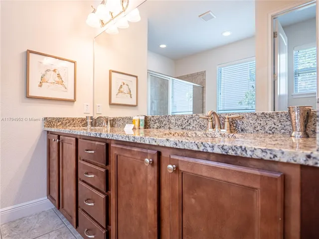 a bathroom with a granite countertop sink and a mirror