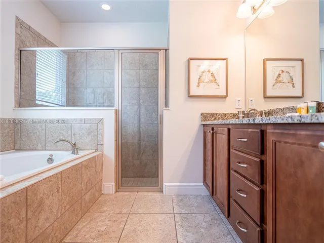 a spacious bathroom with a granite countertop sink and a bathtub