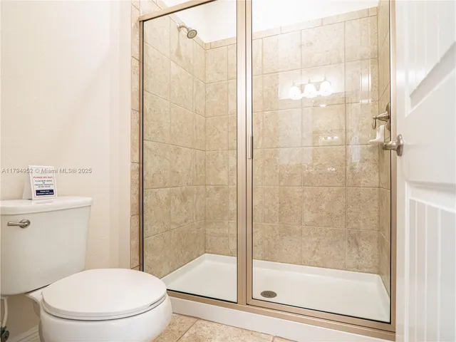 a white toilet next to a bathroom