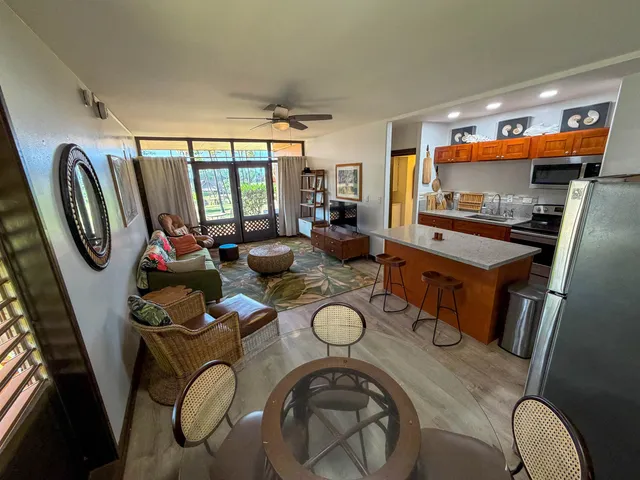 a living room with furniture a flat screen tv and a large window