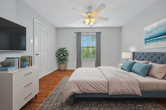 a bedroom with a bed a flat screen tv and dresser