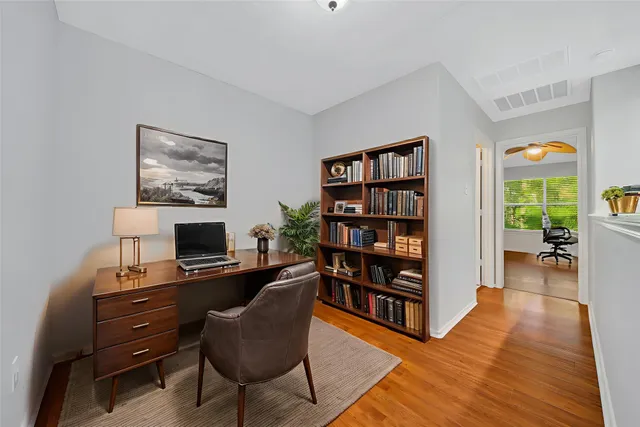 a view of a workspace with furniture and a bookshelf