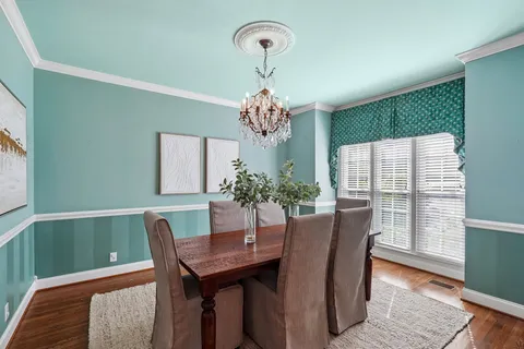 a view of a dining room with furniture and a chandelier
