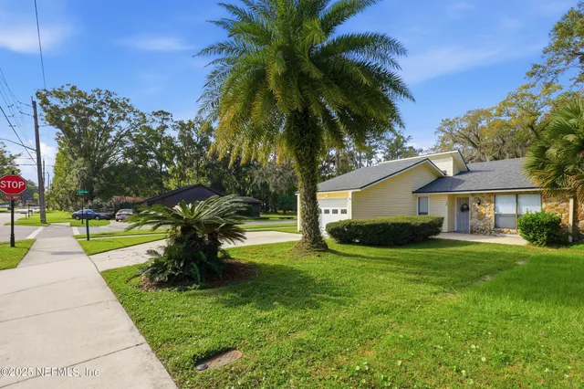 a front view of a house with a yard and trees