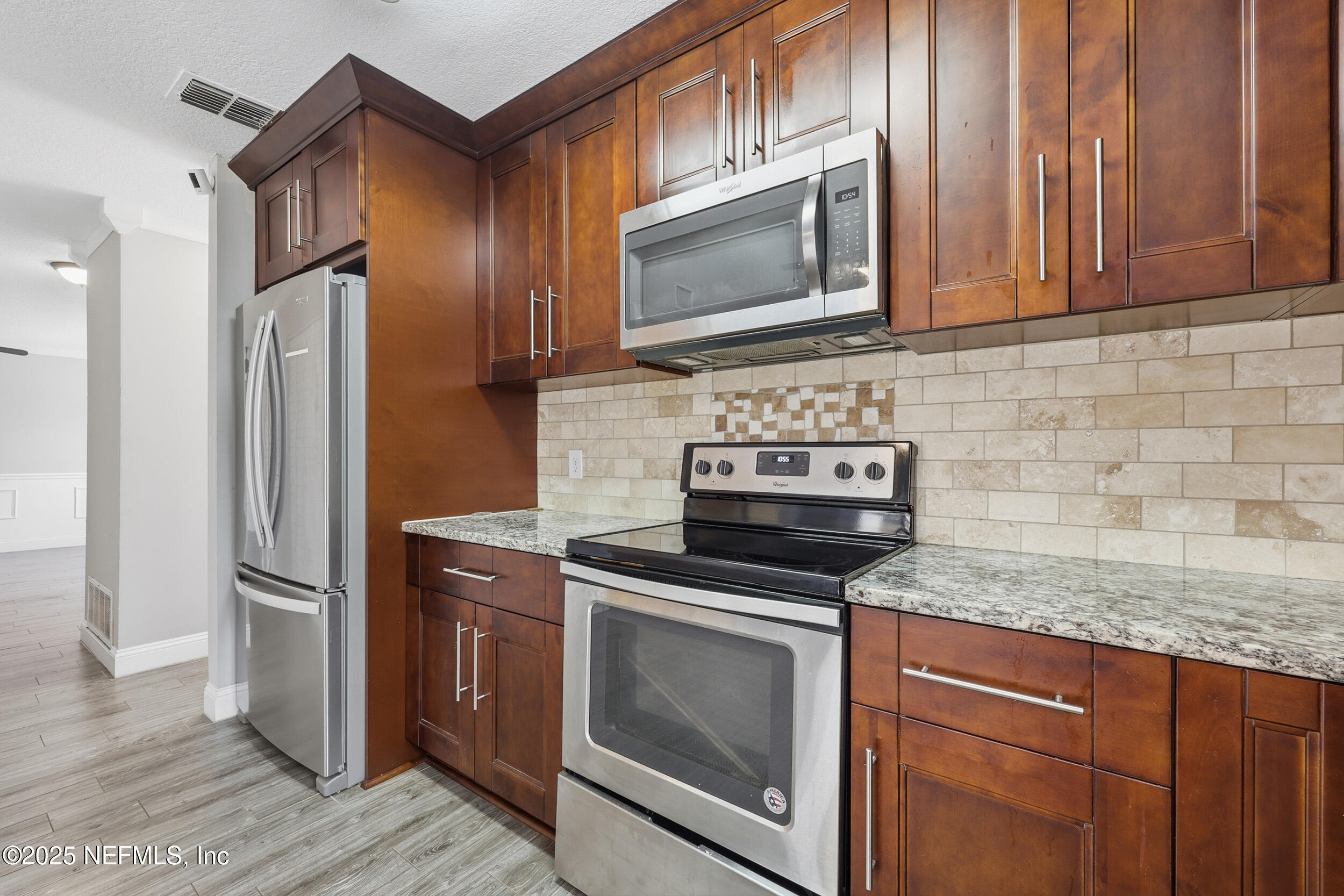 760 Plainfield Avenue Orange Park, FL 32073 - Photo 30 of 38 a kitchen with stainless steel appliances granite countertop a stove microwave and refrigerator