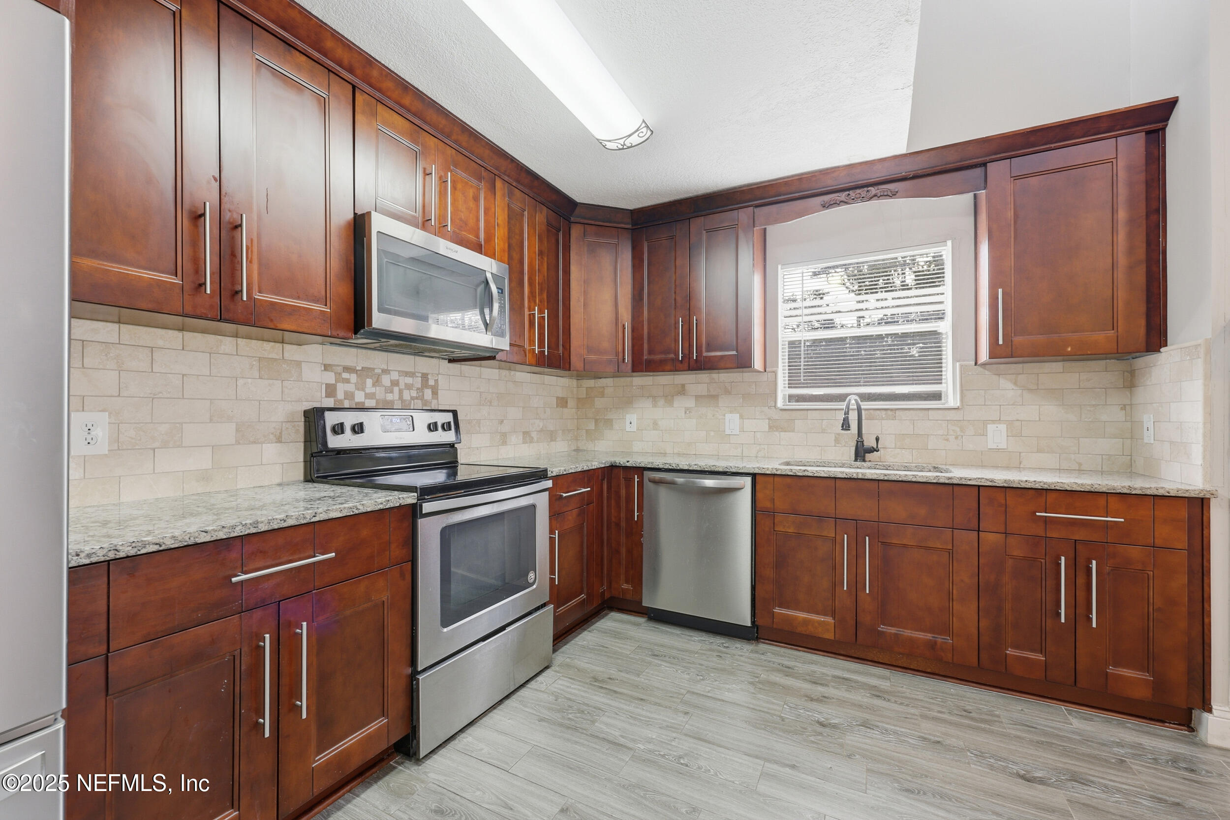 760 Plainfield Avenue Orange Park, FL 32073 - Photo 3 of 38 a kitchen with stainless steel appliances granite countertop wooden cabinets a stove top oven a sink and dishwasher