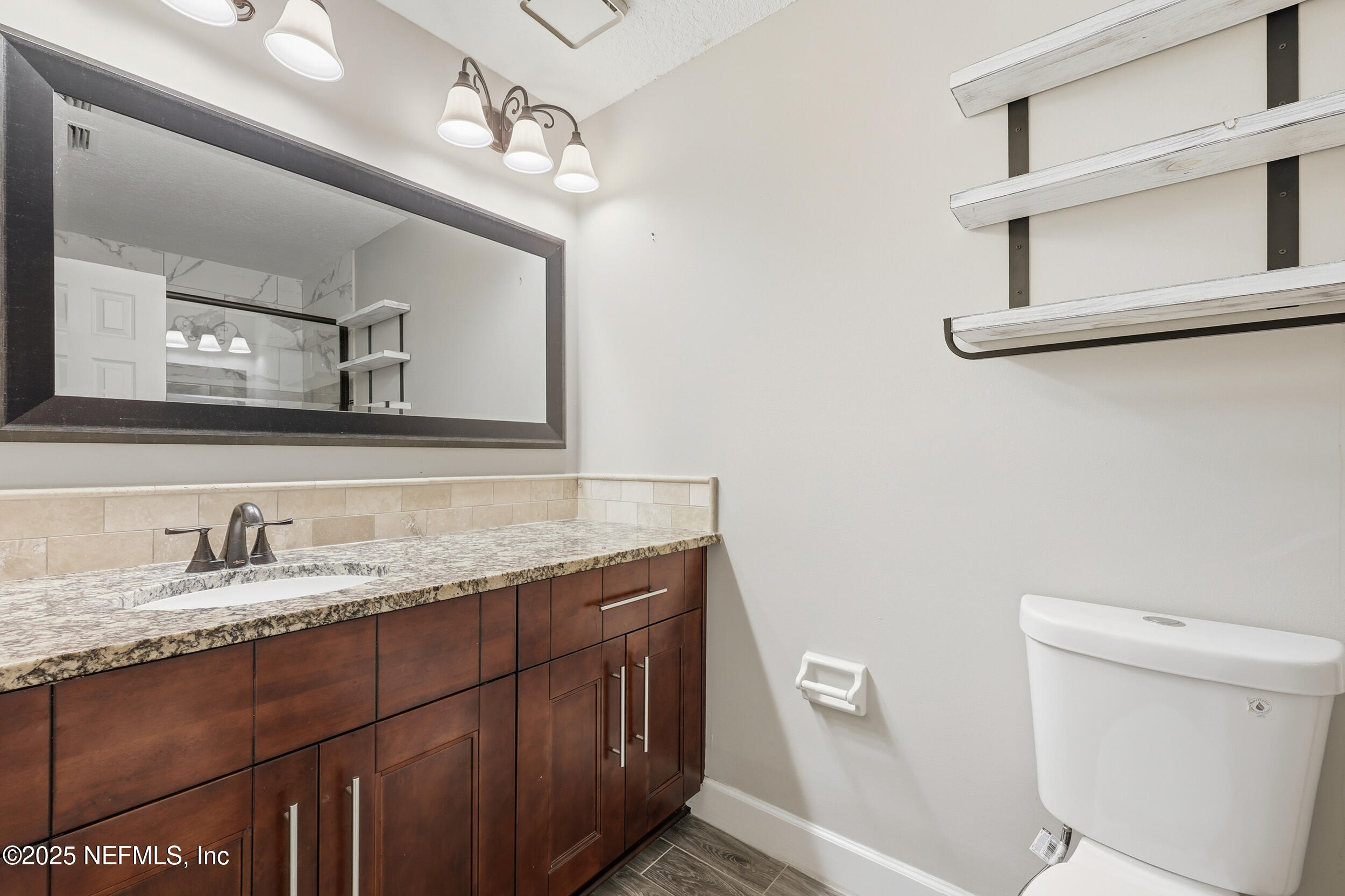 760 Plainfield Avenue Orange Park, FL 32073 - Photo 7 of 38 a bathroom with a granite countertop sink a toilet and a mirror