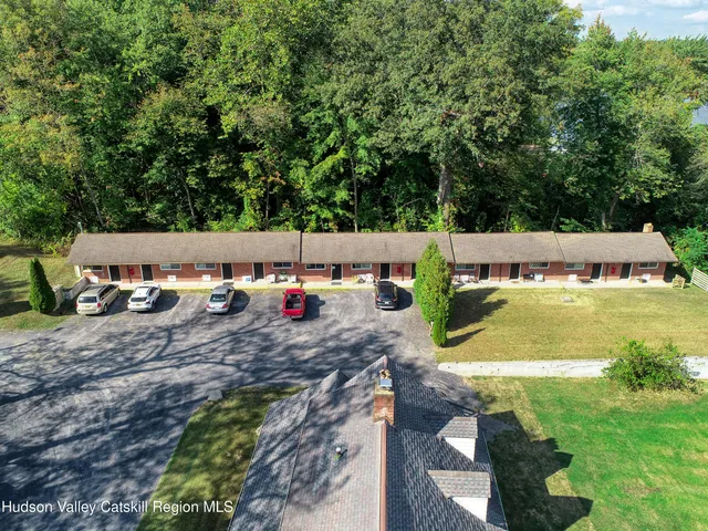 a view of swimming pool with lawn chairs and plants