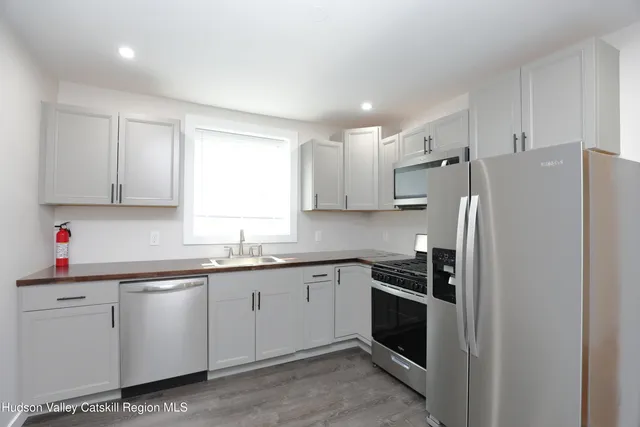 a kitchen with white cabinets and white appliances