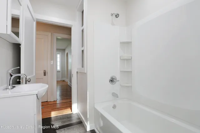 a bathroom with a bathtub sink mirror and toilet