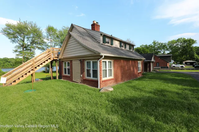 a view of a house with a yard and sitting area