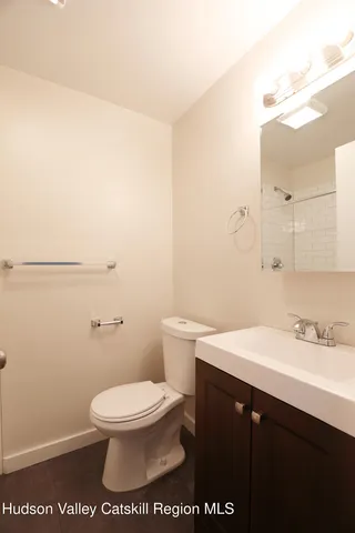 a bathroom with a sink a toilet and a mirror