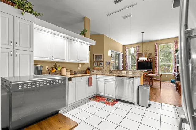 a open kitchen with stainless steel appliances granite countertop a stove top oven a sink a counter top space and cabinets
