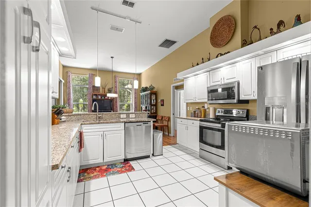 a kitchen with stainless steel appliances granite countertop a refrigerator and a stove top oven
