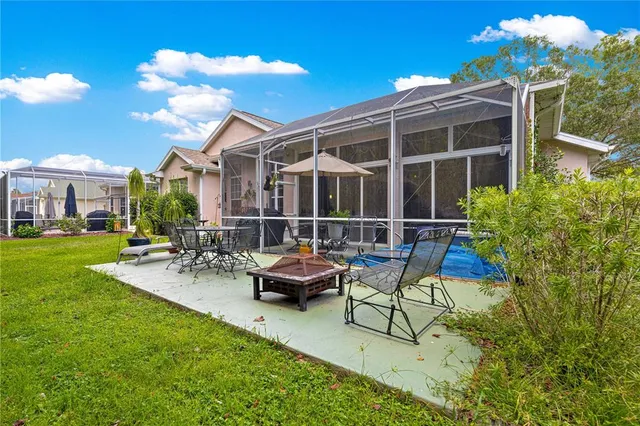 a view of a patio with table and chairs potted plants and large tree
