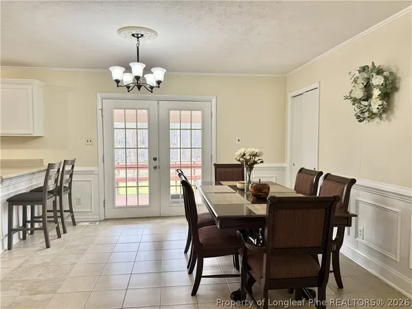 a kitchen with stainless steel appliances a refrigerator a stove a sink dishwasher and a dining table with wooden cabinet