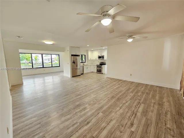 a view of a kitchen with a dishwasher cabinets and wooden floor