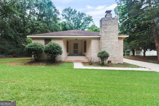 a view of a house with a yard and potted plants