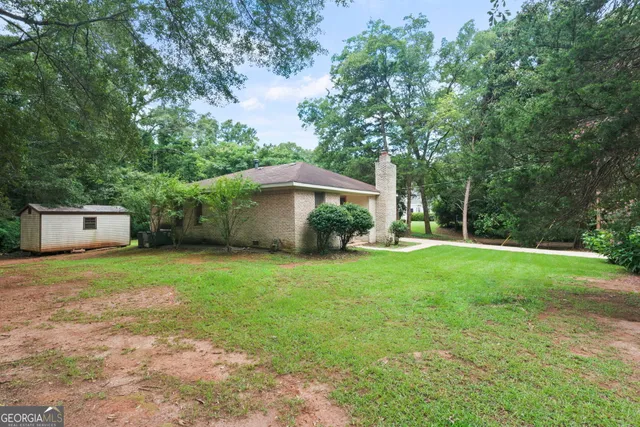 a front view of a house with a yard and trees