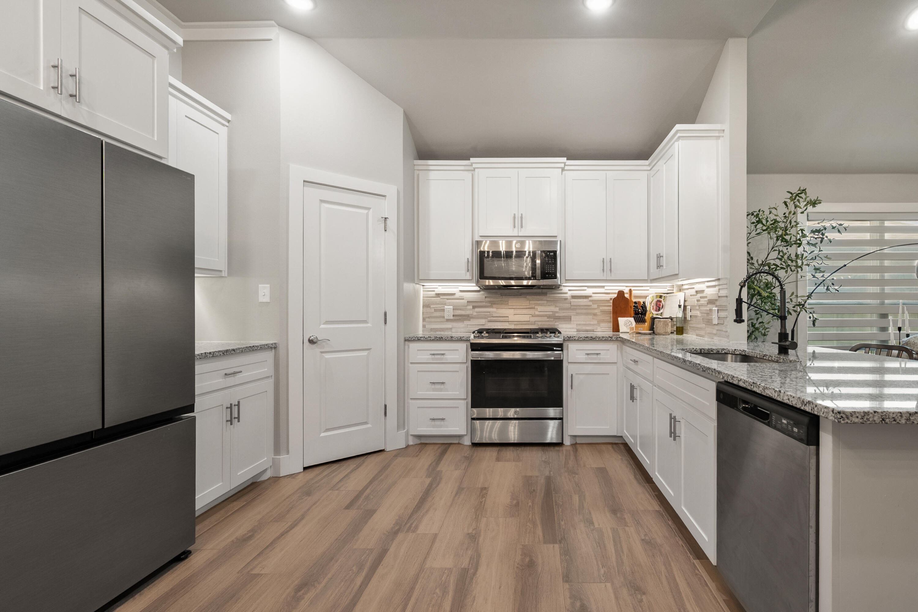2908 137th Street Lubbock, TX 79423 - Photo 12 of 31 a kitchen with stainless steel appliances a sink cabinets and wooden floor