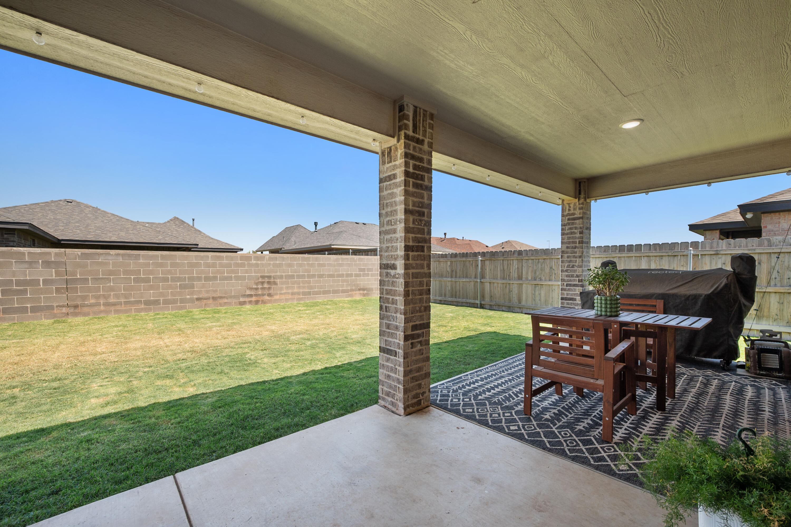 2908 137th Street Lubbock, TX 79423 - Photo 28 of 31 a view of a patio with lawn chairs floor to ceiling window and yard