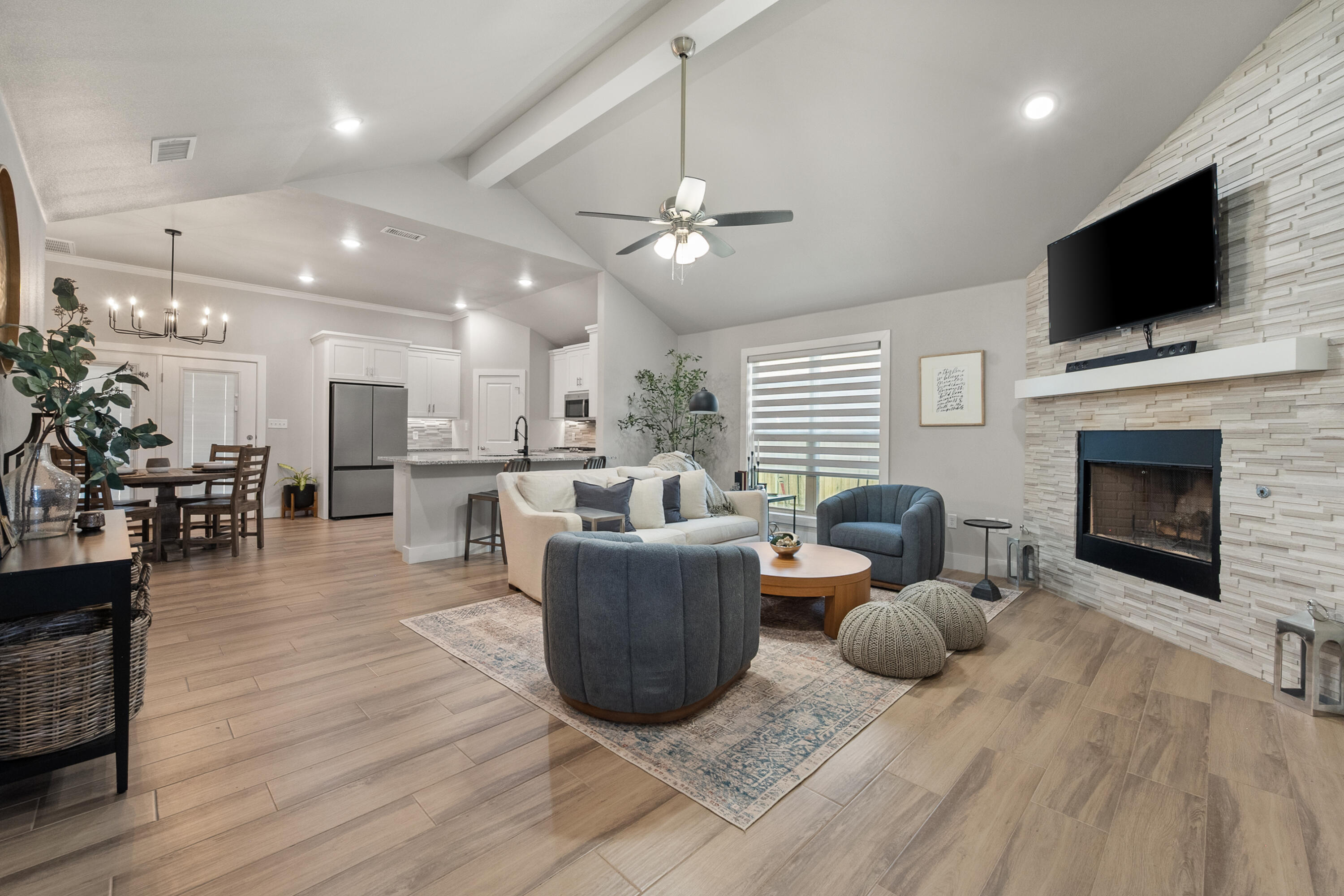 2908 137th Street Lubbock, TX 79423 - Photo 6 of 31 a living room with furniture a flat screen tv and kitchen view