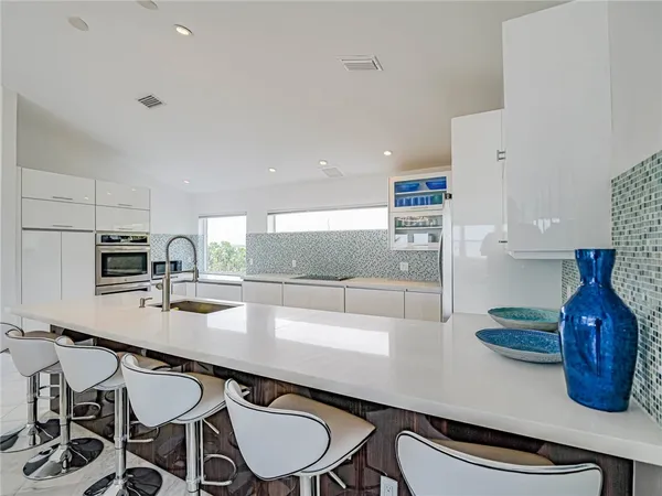 a kitchen with stainless steel appliances granite countertop a sink a stove and a table