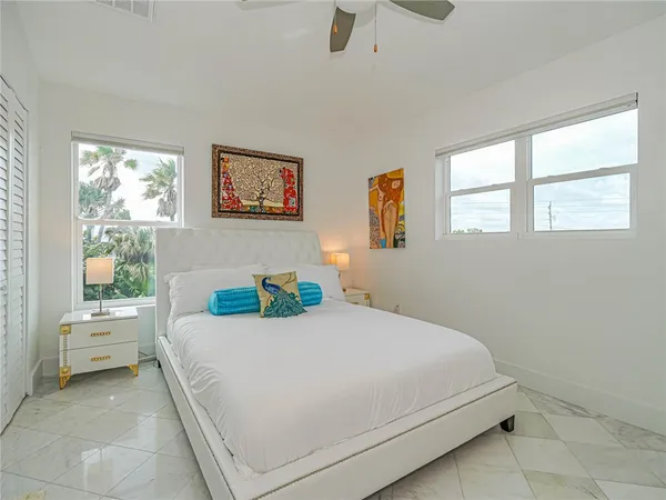 a bedroom with a bed and a large window