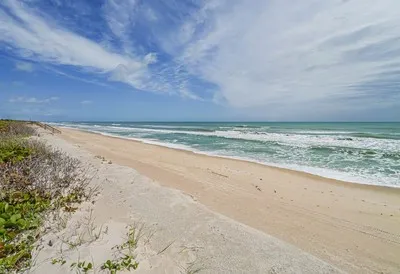 a backyard of a house with table and chairs under an umbrella