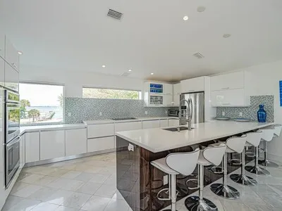 a kitchen with stainless steel appliances granite countertop a table chairs sink and cabinets
