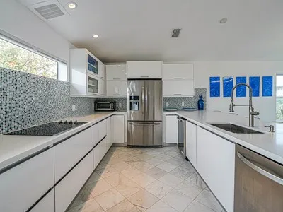 a kitchen with stainless steel appliances granite countertop a sink refrigerator and cabinets