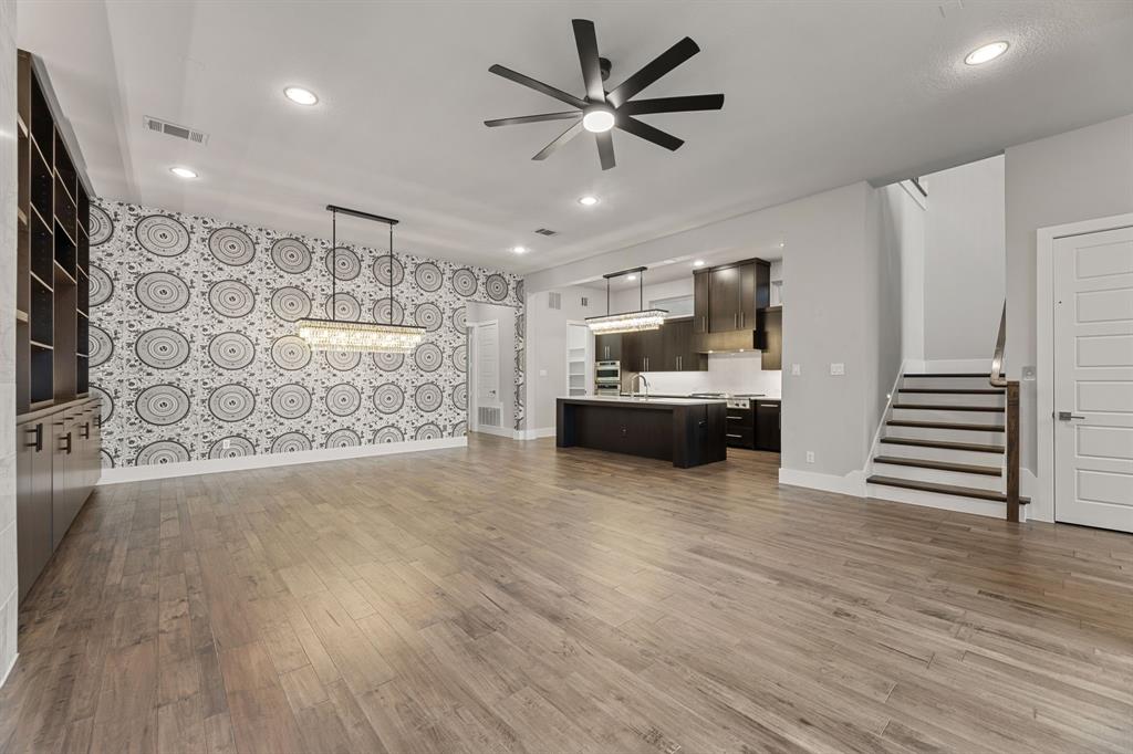 7854 Element Avenue Plano, TX 75024 - Photo 21 of 38 Unfurnished living room featuring stairs, ceiling fan, dark wood-style flooring, recessed lighting, and a chandelier