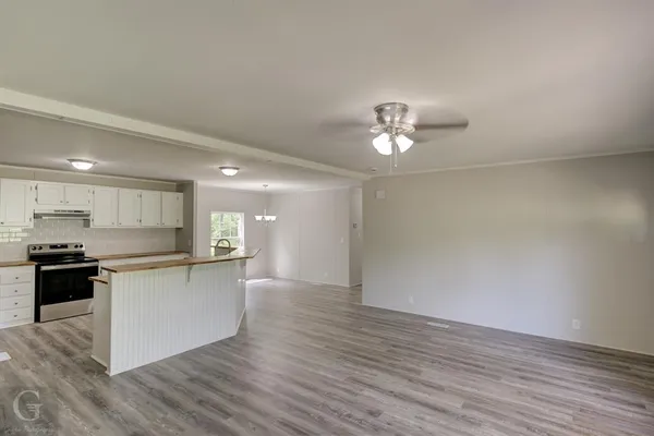 an empty room with wooden floor and window