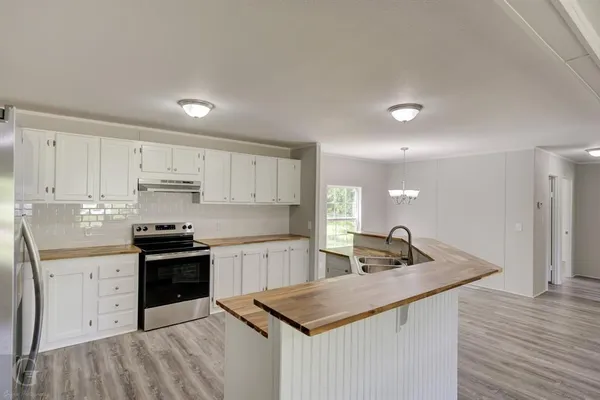 a kitchen with stainless steel appliances granite countertop a sink a stove and refrigerator