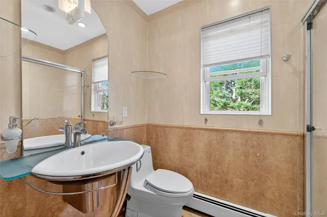 a bathroom with a sink a toilet and a mirror