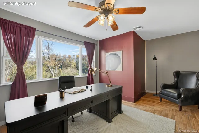 a view of a workspace with furniture and a window