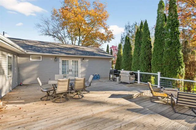 a view of backyard with seating space and trees in the background