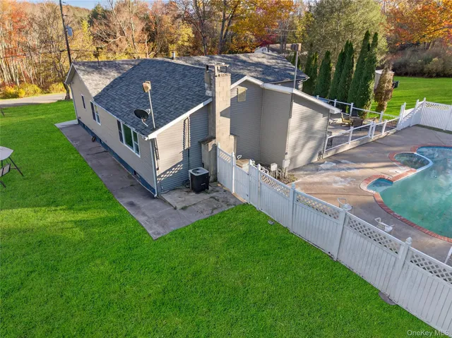a view of an house with backyard and trees