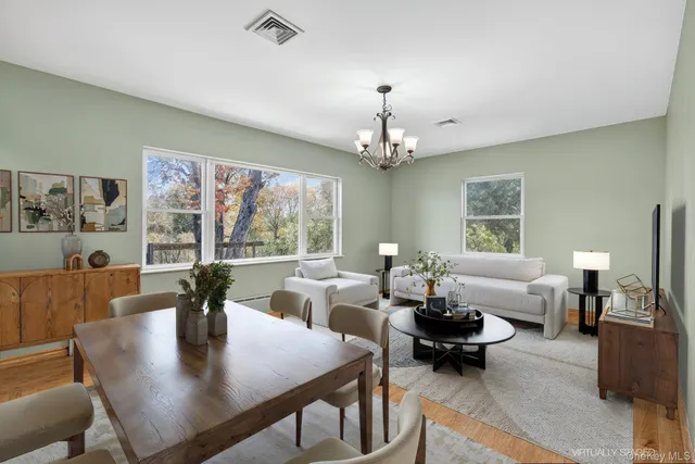 a view of a dining room with furniture a large window and a chandelier