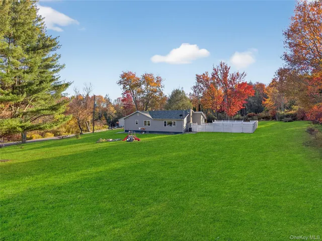 a view of a house with a backyard and a table