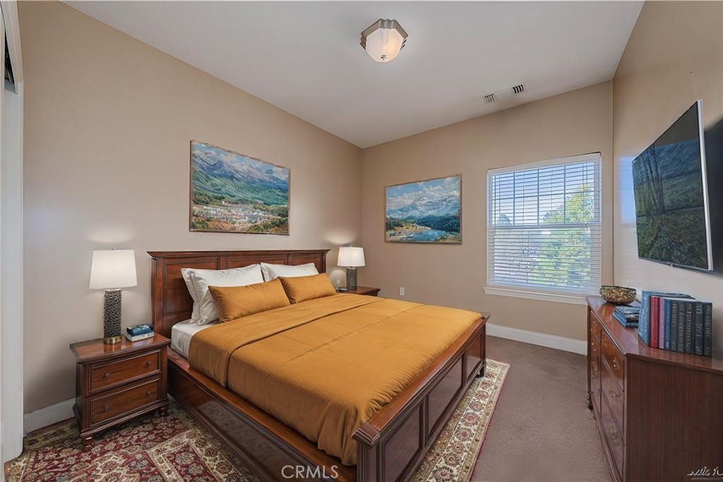 10401 Point Lakeview Road Kelseyville, CA 95451 - Photo 23 of 41 a spacious bedroom with a bed a dresser and a large window