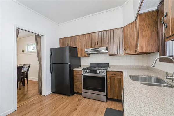 a kitchen with stainless steel appliances granite countertop a refrigerator stove and sink
