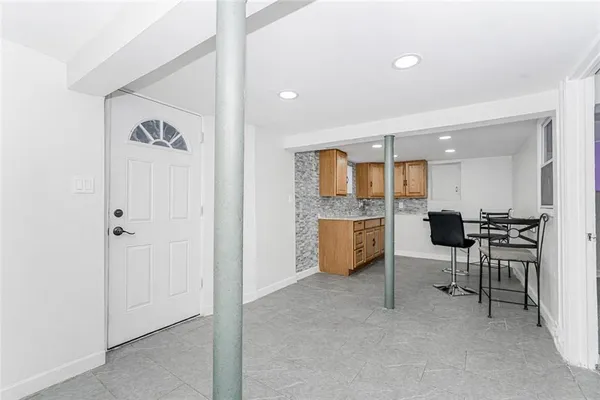 a view of kitchen with a sink wooden cabinets and glass door