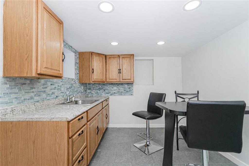 119 Watchogue Road Staten Island, NY 10314 - Photo 21 of 26 a kitchen with granite countertop sink cabinets and chairs