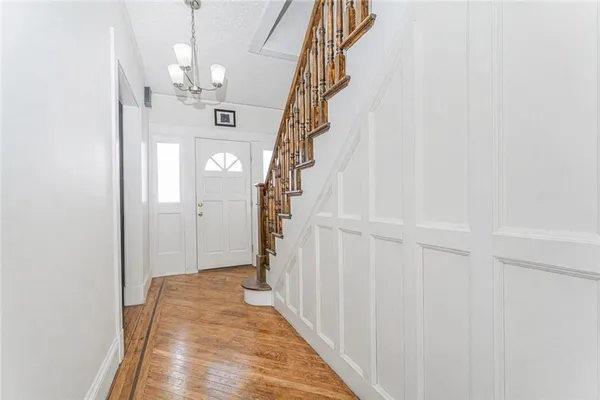 a view of a hallway with wooden floor and staircase